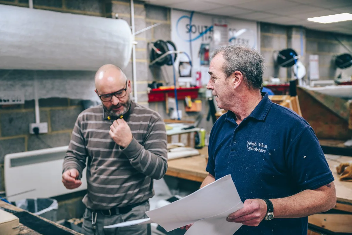 Two workers discussing banquette seating upholstery installation for a client in Covent Garden.